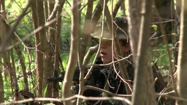 Άνδρες με στρατιωτικές στολές που παίζουν σε στρατιωτικό πολύγωνο airsoft στο δάσος. — Αρχείο Βίντεο