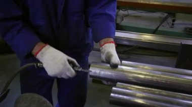 Çalışan eller fabrikadaki paslanmaz profil borularının kenarlarını eziyor..
