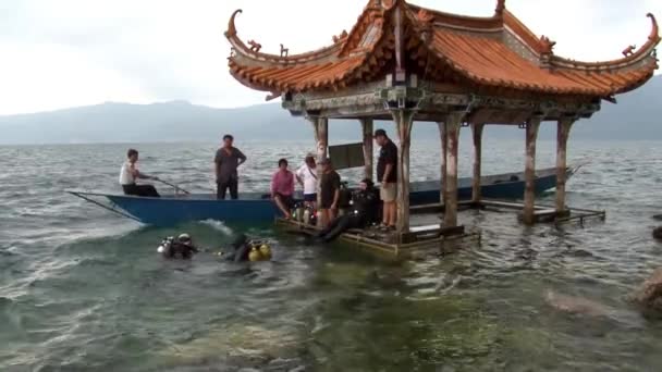 Dalgıçlar Fuxian Gölü 'nde batık bir şehri aramak için suya batar.. — Stok video