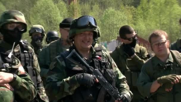 Airsoft team i militär uniform med ett vapen på bakgrunden av skogen. — Stockvideo
