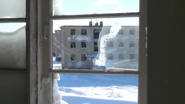 Сніг у зламаних замерзлих вікнах покинутого будинку в покинутому місті . — стокове відео