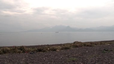 Yunnan Eyaleti 'ndeki Fuxian Gölü' nde sisli bir teknede balıkçı..