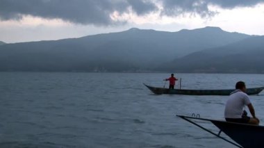 Balıkçılar Fuxian Gölü 'ndeki Çin teknesine balık ağı koyuyor..