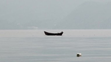 Teknedeki balıkçı Çin 'deki Fuxian Gölü' nde balık ağıyla balık yakalar..