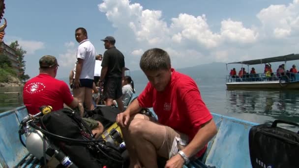 Дайверы плывут на лодке к месту дайвинга в озере Фусянь. — стоковое видео