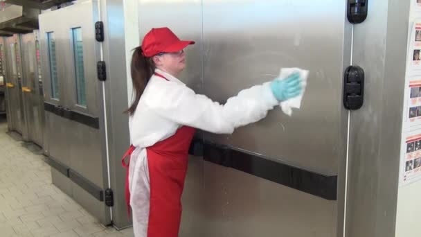 Woman disinfects industrial equipment doors in industrial workshop. — Stock Video