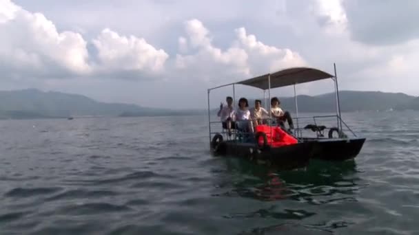Азійці на саморобному катері біля озера Фуксіан.. — стокове відео
