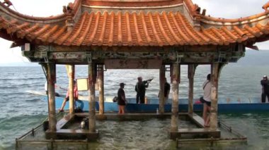 Dalgıçlar Fuxian Gölü 'nde Çin tarzı çatısı olan taraçanın yakınında dalmaya hazırlanıyorlar..