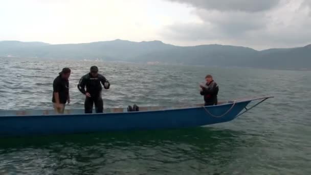 Duikers bereiden zich voor op duiken op sampan chinese boot op Fuxian Lake. — Stockvideo