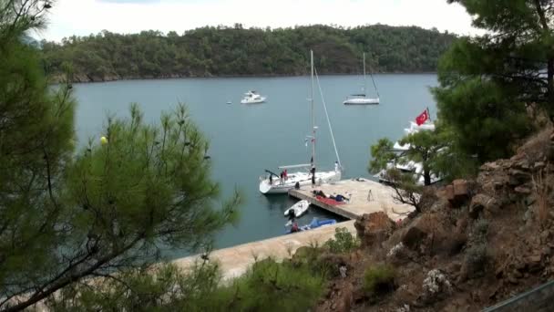 Yacht bianco con persone si trova vicino al molo nella baia. — Video Stock