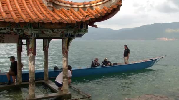 Водолази готуються до дайвінгу біля Вайтгебо з китайським дахом на озері Фуксіан.. — стокове відео