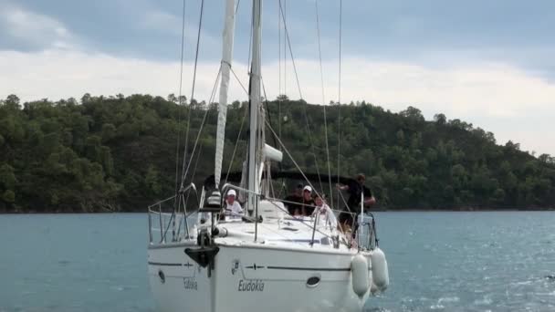 Mensen op witte jachten op de achtergrond van blauwe zee en wolken in de lucht. — Stockvideo