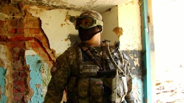 Mann in Militäruniformen spielt in zerstörtem Gebäude des Militärpolygons. — Stockvideo