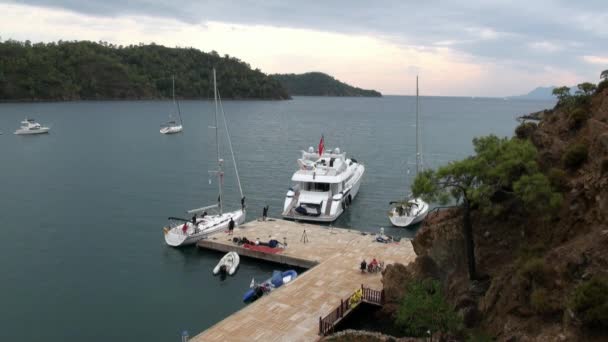 Yacht bianco con persone si trova vicino al molo nella baia. — Video Stock