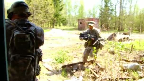 Muži ve vojenských uniformách hrají v zničené budově airsoftu vojenského polygonu. — Stock video