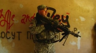 Yıkılmış binanın arka planında Airsoft oyunu.