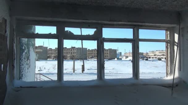 Сніг у зламаних замерзлих вікнах покинутого будинку в покинутому місті . — стокове відео