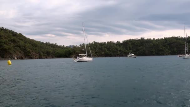 Les gens sur des yachts blancs sur fond de mer bleue et les nuages dans le ciel . — Video