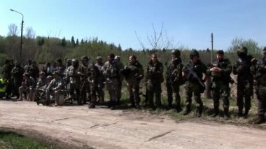 Ormanın arka planında silahlı askeri üniformalı bir hava yumuşaklığı ekibi..