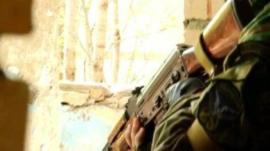 Yıkılmış binanın arka planında Airsoft oyunu.