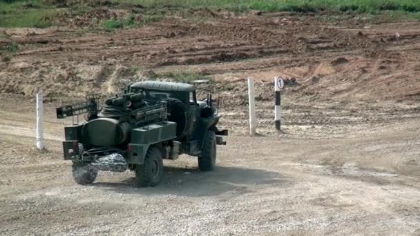 Russische kolom van moderne militaire tanks en uitrusting rijdt langs stoffige weg. — Stockvideo