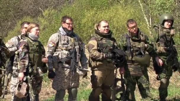 Airsoft tým ve vojenské uniformě se zbraní na pozadí lesa. — Stock video