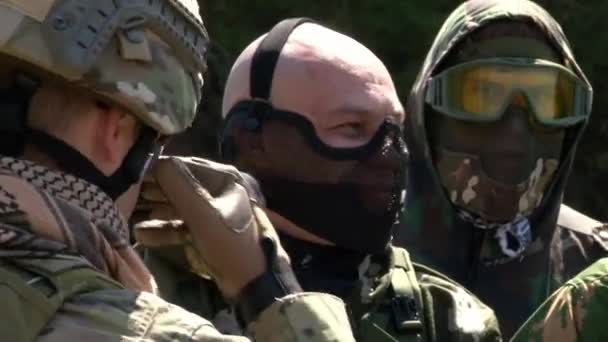 Jugadores de airsoft en uniforme militar con un arma en el fondo del bosque . — Vídeo de stock