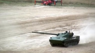 Rus askeri tankları tatbikatlarda tozlu yolda ilerliyor.