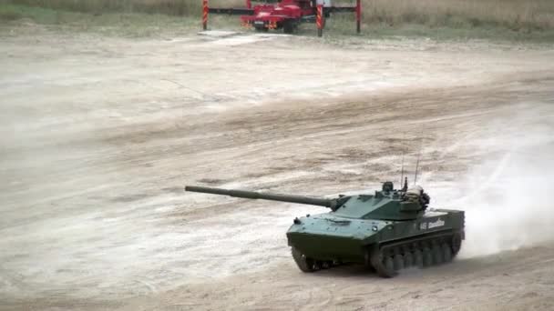 Russian column of military tanks rides along dusty road at exercises. — Stock Video