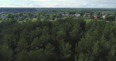 Arka planda gökyüzü ve çarpıcı manzara manzaralı bulutlarla çevrili bir nehir üzerinde evleri ve bahçeleri olan kırsal arazi aracı video panoraması. Açık hava iklimi kavramı.