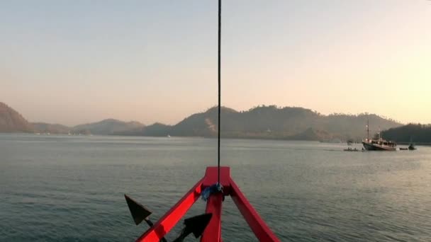 Roter Schiffsbug in Bewegung vor dem Hintergrund der Meeresoberfläche und der Gebirgsinseln. — Stockvideo