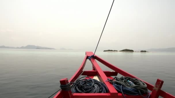 Czerwony łuk statku na tle powierzchni morza i wysp górskich. — Wideo stockowe