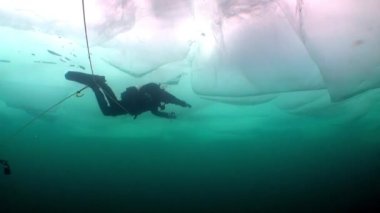 Turkuaz buzun altındaki dalgıç Baykal Gölü 'nün sualtı arka planında.