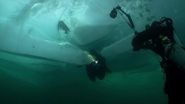バイカルの氷の下で水中カメラマンや技術ダイバーの極端なダイビング. — ストック動画