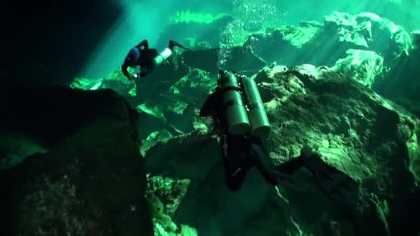 Diver under stalactite stone icicles in cave in underwater Mexico cenotes. — Stock Video