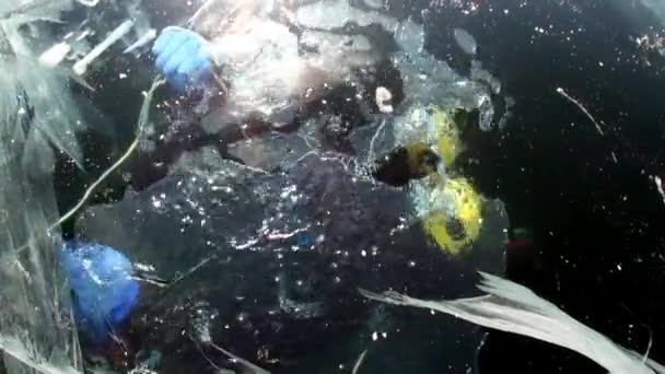 Teknisk dykare under fruset ishål under vattnet i sjön Baikal. — Stockvideo
