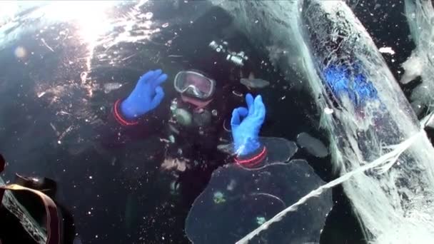 Diver under frozen ice hole underwater of lake Baikal. — Stock Video