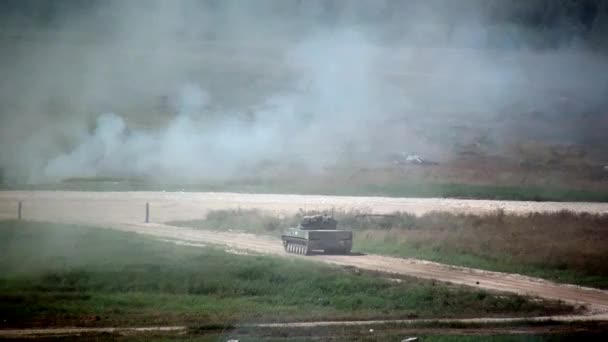 Serbatoio militare russo macchina da guerra cavalcando strada polverosa e spara alle esercitazioni . — Video Stock