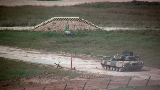 Russische militaire tank oorlog machine rijden stoffige weg en schiet op oefeningen. — Stockvideo
