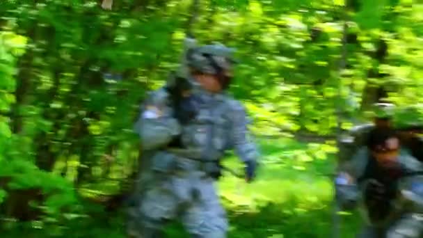 Airsoft jogador em uniforme militar com arma atirar perto de casa arruinada . — Vídeo de Stock