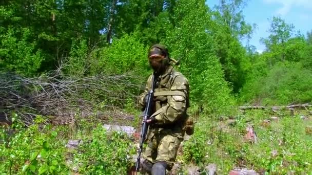 Airsoft hráč ve vojenské uniformě se zbraní střílet v blízkosti zničeného domu. — Stock video