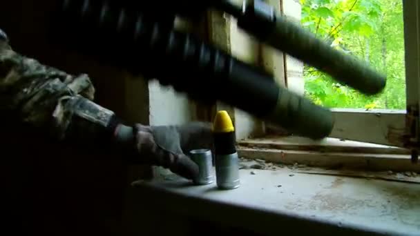 Airsoft spelare i uniform med vapen leder skottlossning från fönstret. — Stockvideo