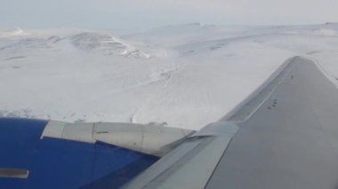Kışın uçan uçak penceresinden uçak kanadı manzarası.