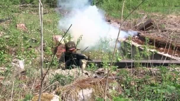 Jugador de Airsoft en uniforme militar con arma de fuego cerca de casa arruinada . — Vídeos de Stock