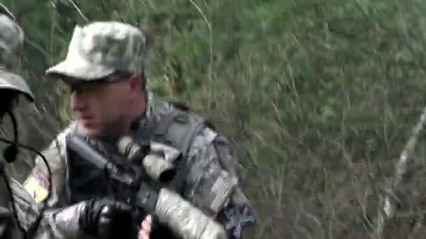 Airsoft spelare i militär uniform med vapen i skogen. — Stockvideo