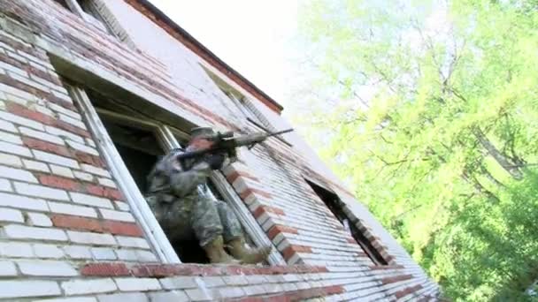 Airsoft spelare i militär uniform med vapen skjuta nära förstört hus. — Stockvideo