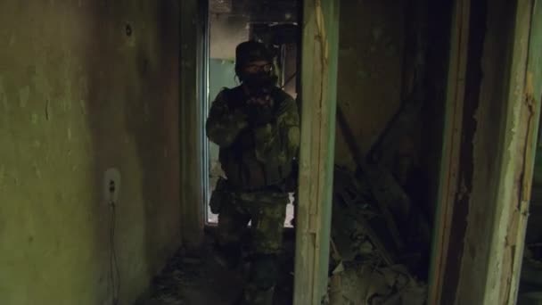 Jugador de Airsoft en uniforme militar con arma en casa arruinada. — Vídeos de Stock