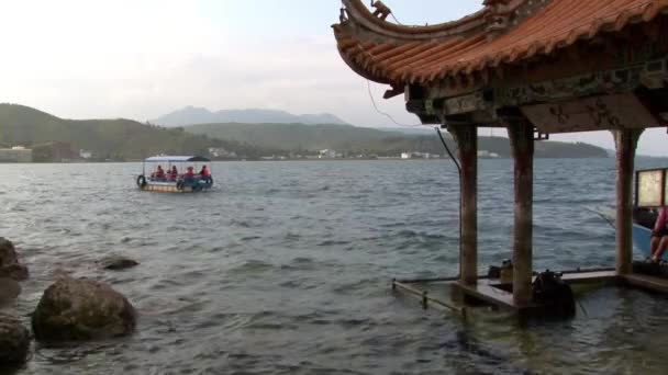 Taucher bereiten sich auf Tauchgänge in der Nähe eines Pavillons mit chinesischem Dach im Fuxian-See vor. — Stockvideo