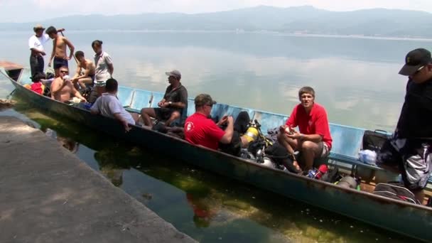 Dykare simmar på en båt till dykplatsen i Fuxian Lake. — Stockvideo