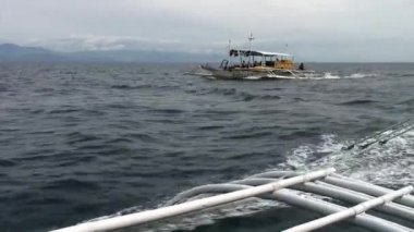 Filipinler 'de insanlar Filipinler' de bambu kanatlarla filipin teknesine biniyorlar..